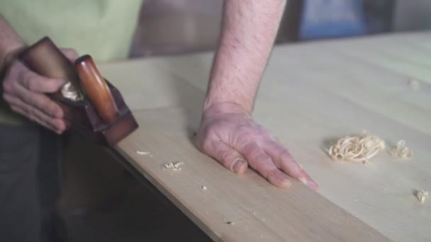 Mains d'un menuisier en chemise dans un atelier avec un avion au travail — Video