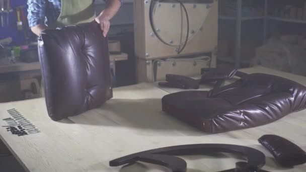 El hombre en el delantal con la barba, se ocupa del montaje de los muebles en el taller — Vídeo de stock