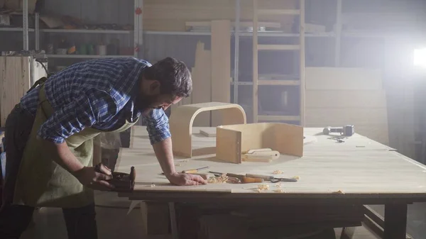 portre kraftman atölye gömlekli sakallı bir adam bir ağaç talaşı ile uçak