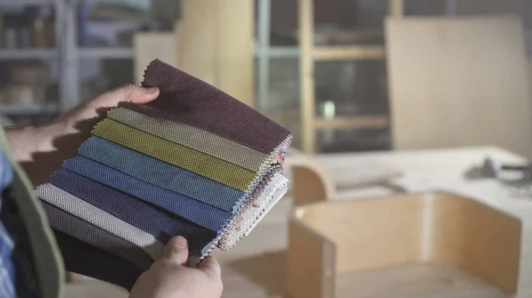 Erkekler Kraftman elinde mobilya imalatı için renkli kumaş örnekleri