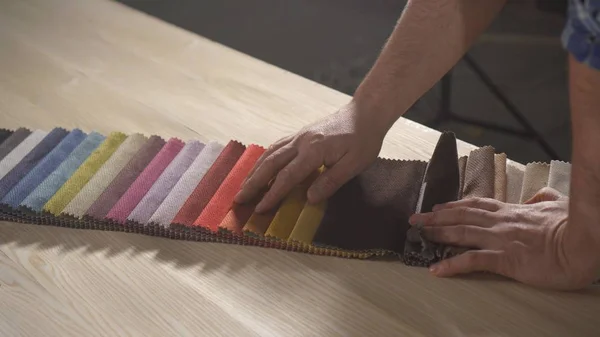 otantik bir atölye sakallı bir adam elinde mobilya yapmak için renkli kumaş örnekleri