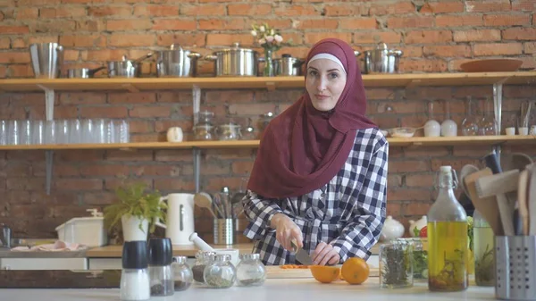 年轻的穆斯林妇女在厨房切蔬菜做饭 — 图库照片
