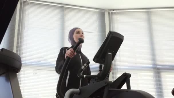 Mujer deportiva en hijab en simulador de paso, muslim fitness — Vídeos de Stock