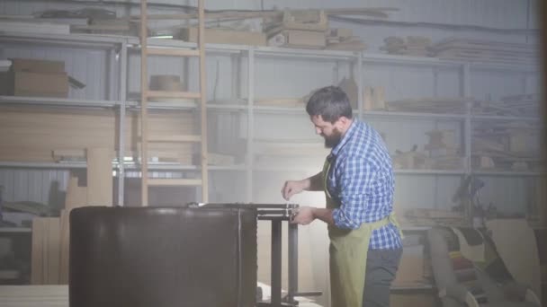 Male professional furniture maker, assembles the chair in the workshop — Stock Video