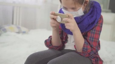 Kamera evde yatakta oturup seyir tıbbi maskesi ile genç kız portresi