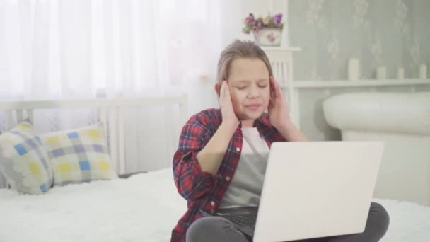 Portrait severe headache in a child who sits at the laptop doing homework — Stock Footage Portrait Severe Headache Child Who Sits Laptop Doing Homework Royalty Free Stock Video