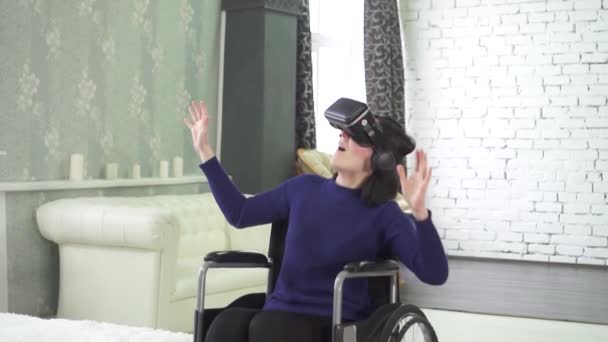 Young disabled woman in a wheelchair, uses vr helmet, 3D technology — Stock Video