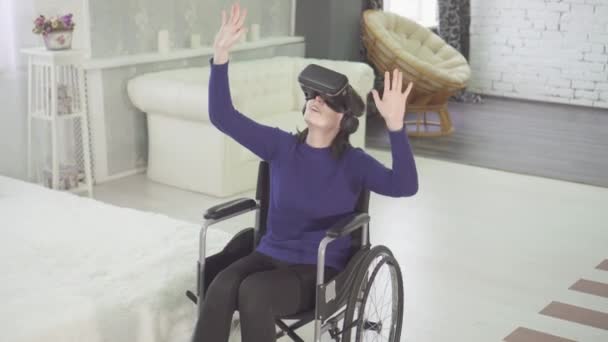 Donna una persona disabile in sedia a rotelle utilizza la tecnologia 3d, vr casco — Video Stock