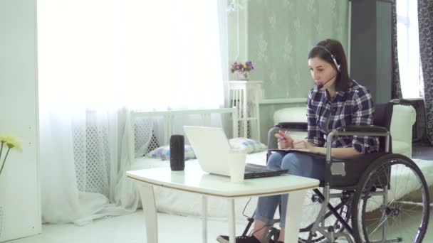 Jeune femme handicapée, fauteuil roulant, télétravail à la maison, casque d'ordinateur — Video