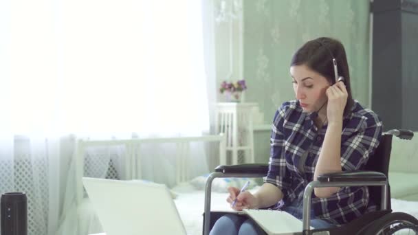 Retrato mujer joven discapacitada, silla de ruedas, trabajo remoto en casa, auriculares para computadora — Vídeo de stock