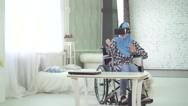 Mulher em hijab, cadeira de rodas, usa óculos VR, tecnologia 3D, viagens virtuais — Vídeo de Stock