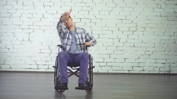 Alegre y positivo discapacitado bailando sentado en una silla de ruedas, sonriendo — Vídeo de stock