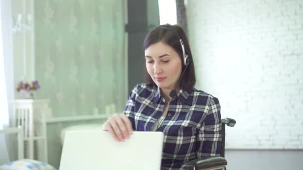 Jeune femme handicapée, fauteuil roulant, télétravail à la maison, casque d'ordinateur — Video