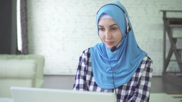 Retrato de una joven hermosa mujer en hijab con auriculares y auriculares, centro de cal trabajador — Vídeos de Stock