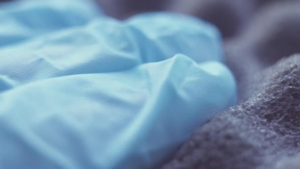 Mano en guantes azules presiona esponja absorbente de sonido — Vídeo de stock