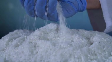 Anti-icer reaktif içinde beyaz tanecikler, yakın çekim, eldivenli elini