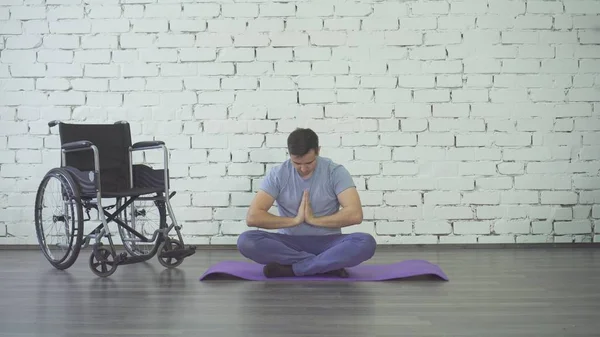 Yoga, Tekerlekli sandalye ve egzersiz minderi yapan Engelli erkek