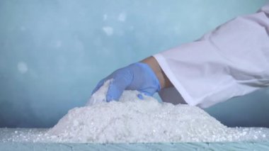 Beyaz granül reaktif anti-icer, Laboratuvar el eldivenli.