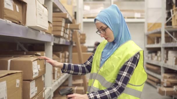 Muslima im Hijab-Laden mit Barcode-Scanner — Stockvideo