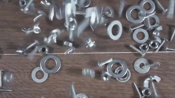 Bolts nuts screws fall on the table — Stock Video
