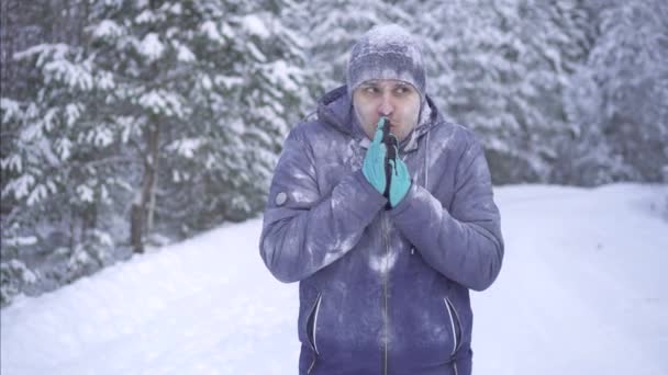 Un hombre congelado sobre un fondo de nieve, confundido, con una pregunta — Vídeo de stock