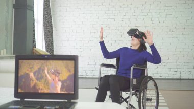 Tekerlekli sandalyedeki genç güzel bir engelli kadın evde, 3d teknolojisi, vr kask kullanır