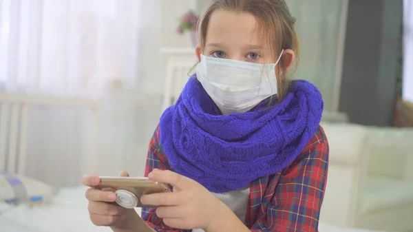 Kamera evde yatakta oturup seyir tıbbi maskesi ile genç kız portresi