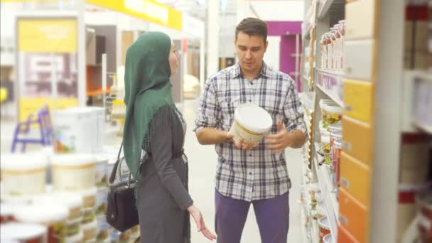 Verkäuferberater im Supermarkt berät eine Muslimin — Stockvideo