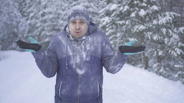 Confundido hombre congelado en el bosque de invierno mira a la cámara Fotos De Stock