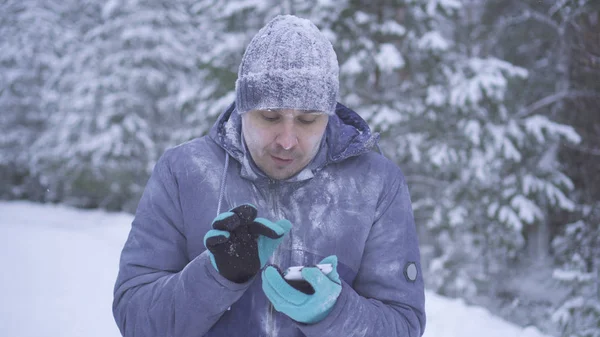 Hombre congelado en el bosque de invierno utiliza el teléfono Imagen De Stock