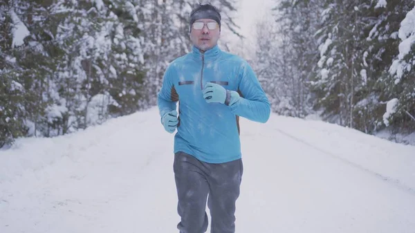 Portrait of a man 30 years old, running through the winter forest Stock Image