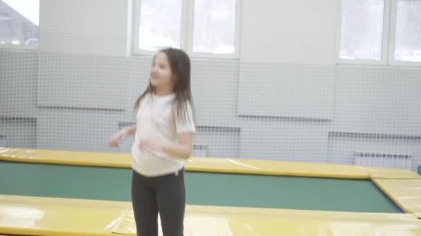 Neşeli genç kız bir trambolin üzerinde atlama — Stok video