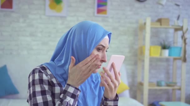 Hermosa joven musulmana mujer disgustado se ve en el espejo — Vídeos de Stock