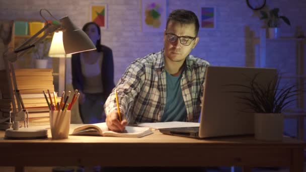 Πορτρέτο ενός νεαρού οικογένεια άνθρωπος καταπονημένος κάθεται σε ένα φορητό υπολογιστή τη νύχτα — Αρχείο Βίντεο