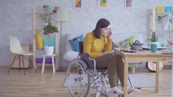 Jonge vrouw met een handicap in een rolstoel te maken Make-up — Stockvideo