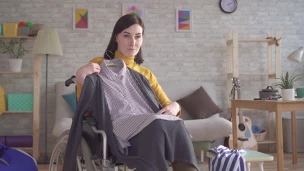 Jonge gehandicapte meisje in een rolstoel gaat op een datum proberen op kleding — Stockvideo