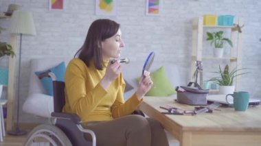 Bir tekerlekli sandalyede genç bir özürlü kadının portre bir tarihe gidiyor makyaj yapıyor