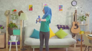 Tesettür sportif Müslüman kadın evde Dambıl ile uğraşan