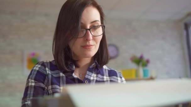Porträt einer jungen Frau, die mit positiver Emotion an einer alten Schreibmaschine arbeitet — Stockvideo