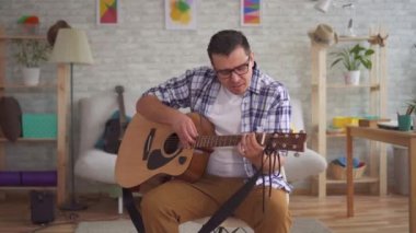Gözlük ile genç adam müzisyen gitar çalabilir