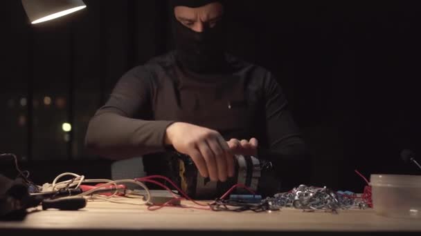 Unrecognizable terrorist wearing a balaclava against the backdrop of the night city — Stock Video