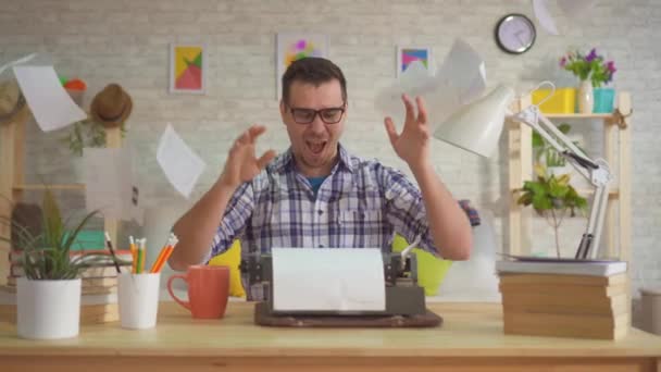 Schriftsteller arbeitet zu Hause, wirft Papierbögen und tippt begeistert auf einer alten Schreibmaschine. — Stockvideo