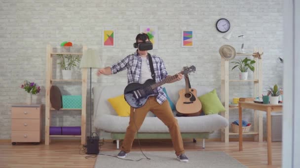 Jonge man muzikant in virtual reality bril emotioneel het spelen van de elektrische gitaar — Stockvideo