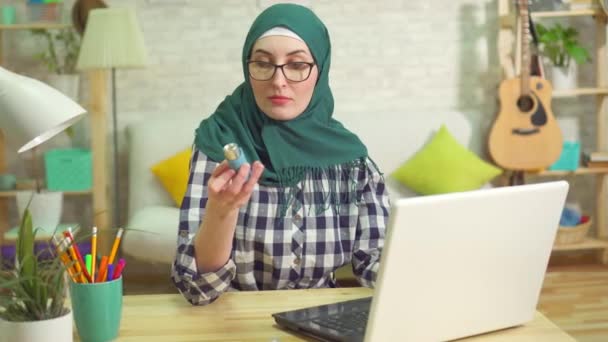 Jonge moslimvrouw zoeken op het Internet voor een astma-inhalator — Stockvideo