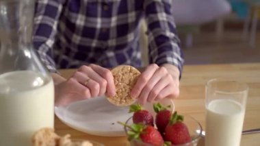 Genç kadın kahvaltıda ekmek yiyor. Sağlıklı kahvaltı