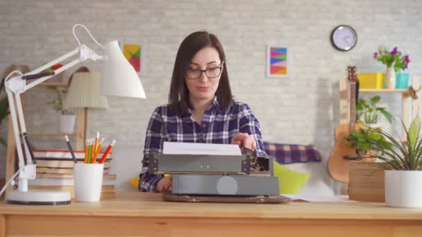 Молодая женщина печатает с вдохновением на пишущей машинке — стоковое видео