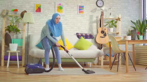 Втомлена мусульманка в хіджабі вакуумний килим — стокове відео