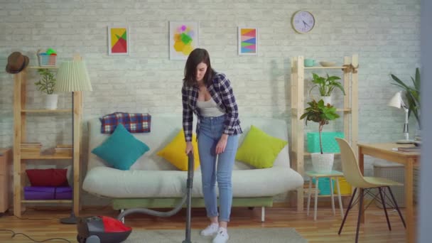 Junge Frau zu Hause staubsaugt den Teppich und beginnt zu niesen, das Konzept der Allergie gegen Staub — Stockvideo