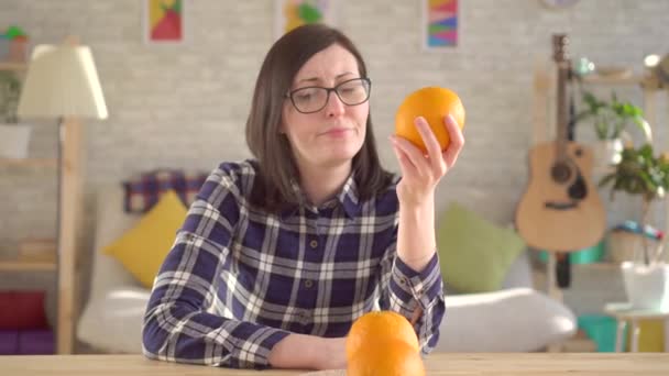 Alérgica a las naranjas. La joven olfatea y mira las naranjas — Vídeos de Stock