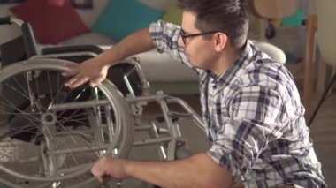 Tekerlekli sandalyeyi onararak genç bir adamın portresi